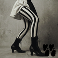 Black and white bold vertical stripe leggings by YéYé, styled with a black and white puff sleeve mini dress and black Victorian lace-up heeled boots