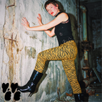 Studio-yeye-Tiger-Animal-Print-Yellow-Mustard-Punk-Style-Leggings-pixie cut hair model wearing punk style tank and the leggings, with patent boots at old warehouse 