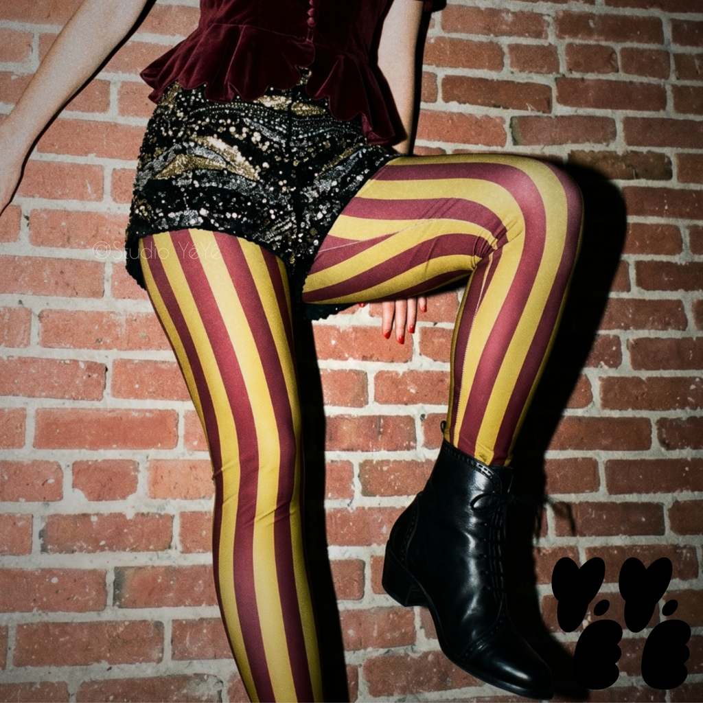 Circus Circus leggings in burgundy and gold vertical stripes by Studio YéYé, styled with sequin shorts and black ankle boots.