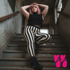 A pink hair plus size female model wears size 2XL circus stripe leggings in black and white