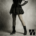 Mismatched black and white polka dot leggings by YéYé, styled with a black bubble skirt, black corset vest and long black leather gloves with black lace-up Victorian boots