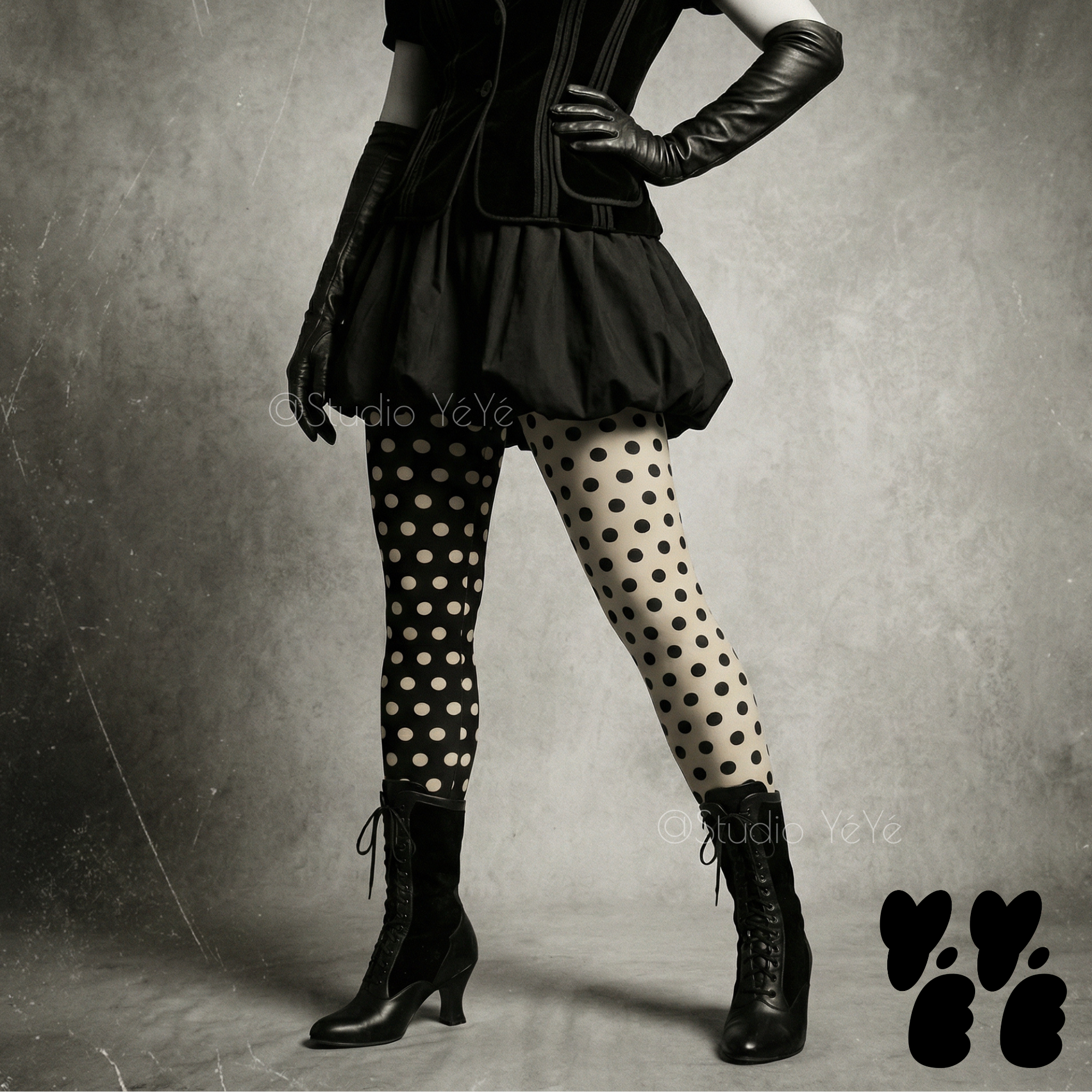 Mismatched black and white polka dot leggings by YéYé, styled with a black bubble skirt, black corset vest and long black leather gloves with black lace-up Victorian boots