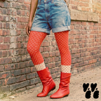Two-tone red and cream polka dot leggings by YéYé, styled with denim cut-off shorts and red leather slouch boots against a brick wall
