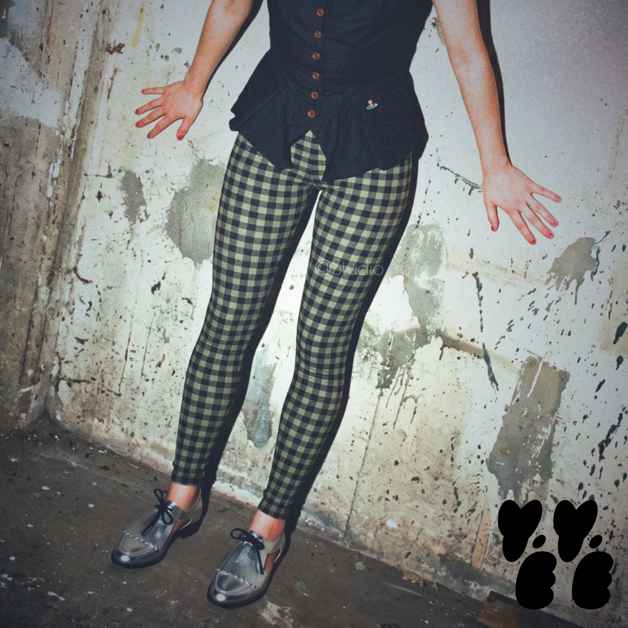 A woman wears studio yeye's gingham leggings moss green black with vivianne westwood tops and silver shoes