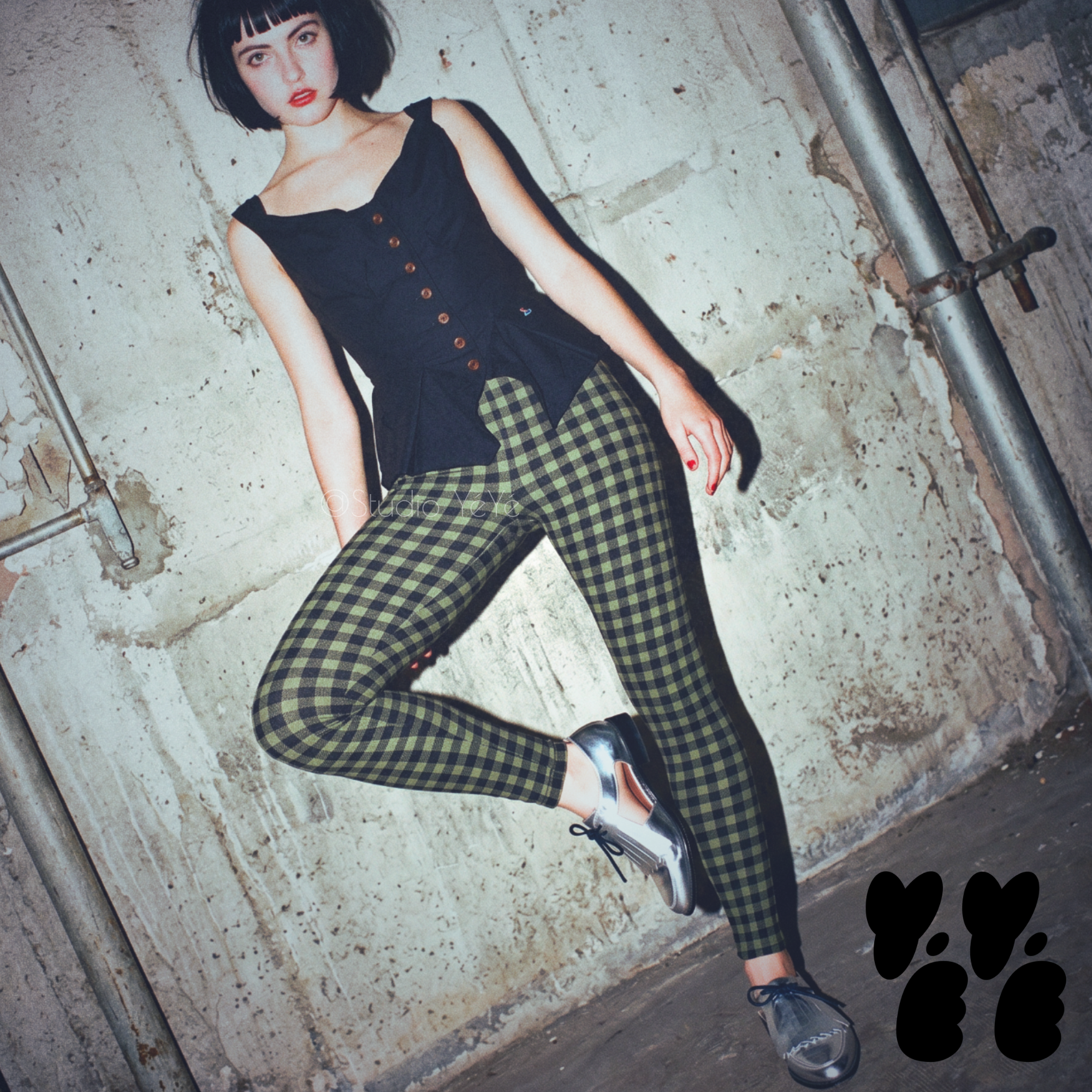 A woman wears studio yeye's gingham leggings moss green black with vivianne westwood tops and silver shoes