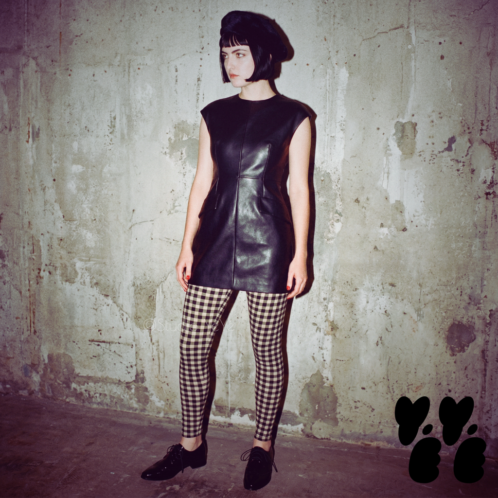 Black and white gingham leggings by YéYé, styled with a white oversized top and two-tone saddle shoes at night in a park