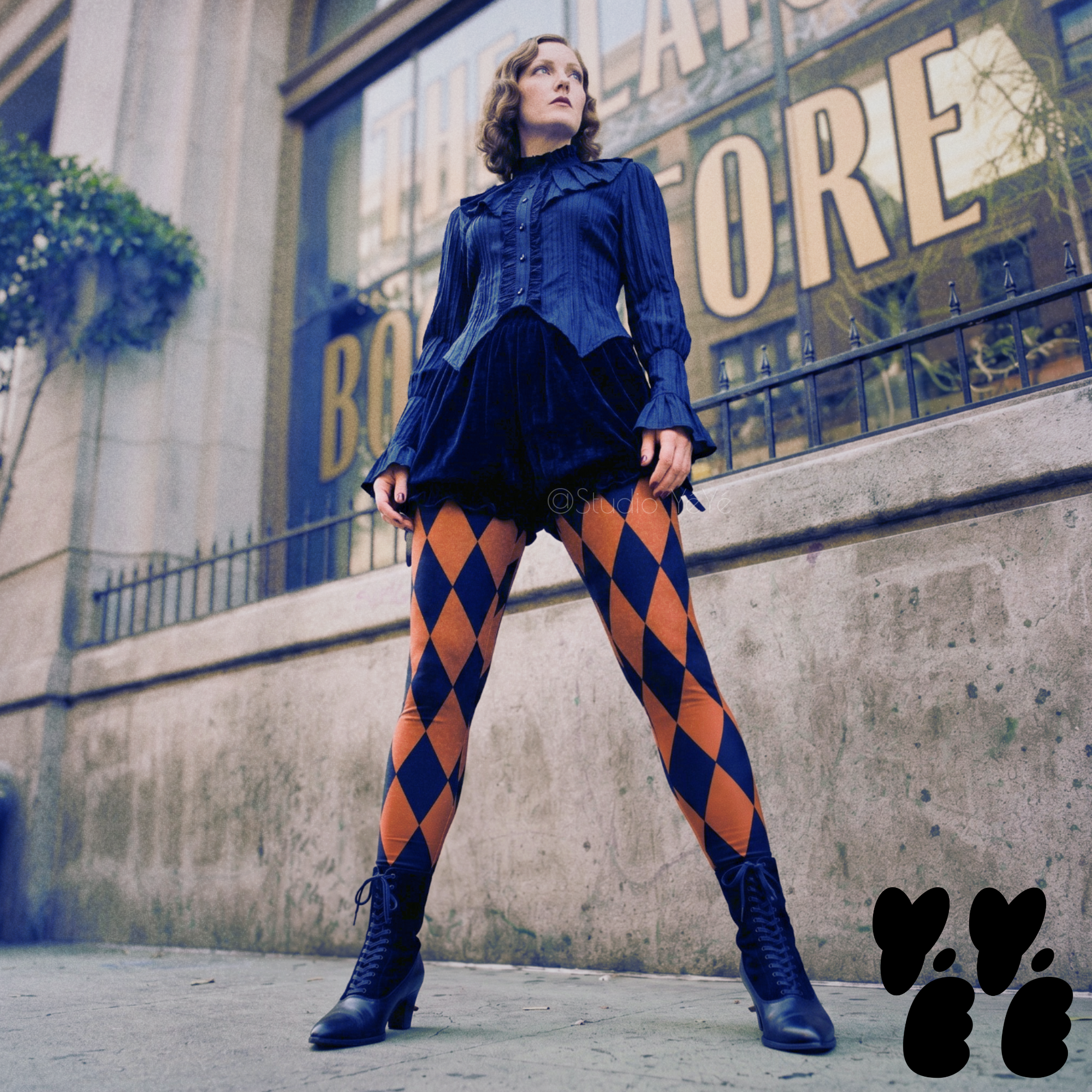 A female model wears harlequin diamond tights with black shorts and victorian boots, standing front of The Last Bookstore in Los Angeles downtown