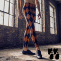 Burnt orange and black harlequin diamond mens leggings by YéYé, styled with black jazz shoes in an industrial warehouse