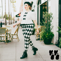A plus size female model wears 2XL harlequin diamond leggings in black and white