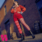 Pink and red harlequin jester leggings by YéYé with mismatched stripe and diamond pattern, styled with a red satin ruffle blouse, red scalloped shorts and black Victorian lace-up boots