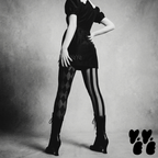 Mismatched harlequin diamond and stripe leggings in silent film grayscale by YéYé, styled with a black puff sleeve mini dress with white lace collar and black lace-up heeled boots