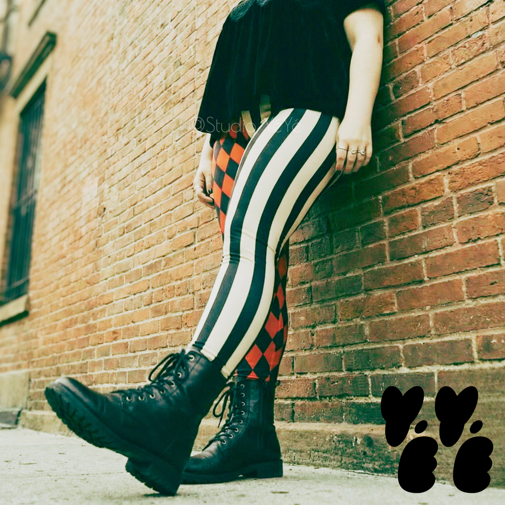 A plus sized female model wears harlequin jester leggings with combat boots