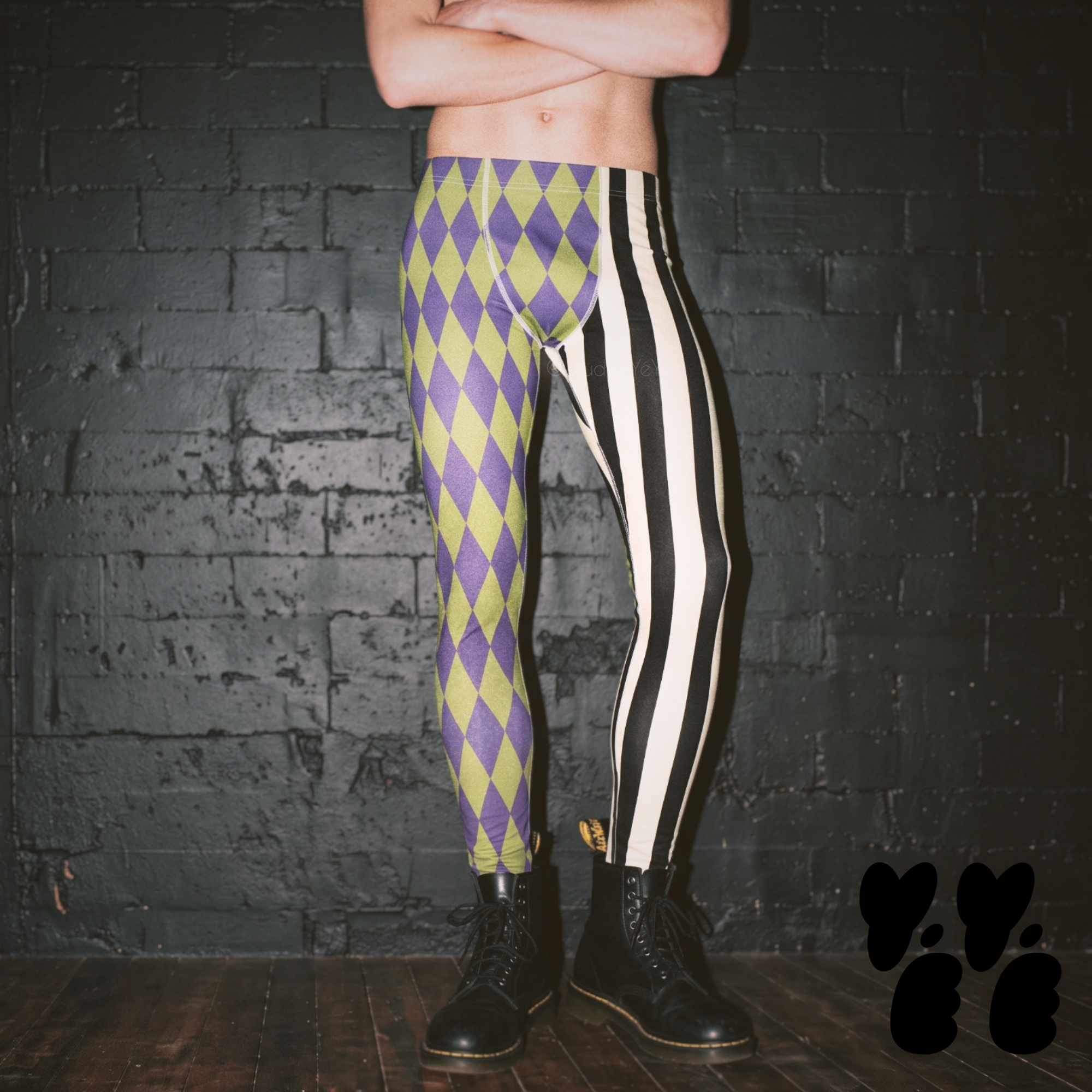 A make model wears harlequin jester printed leggings, vintage purple and acid green, black and off white stripe mix with dr marten boots.