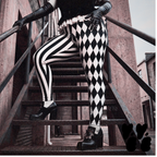 A female model wears velvet bustier, black leather gloves and black and white jester leggings from studio yeye with goth punk style platform shoes