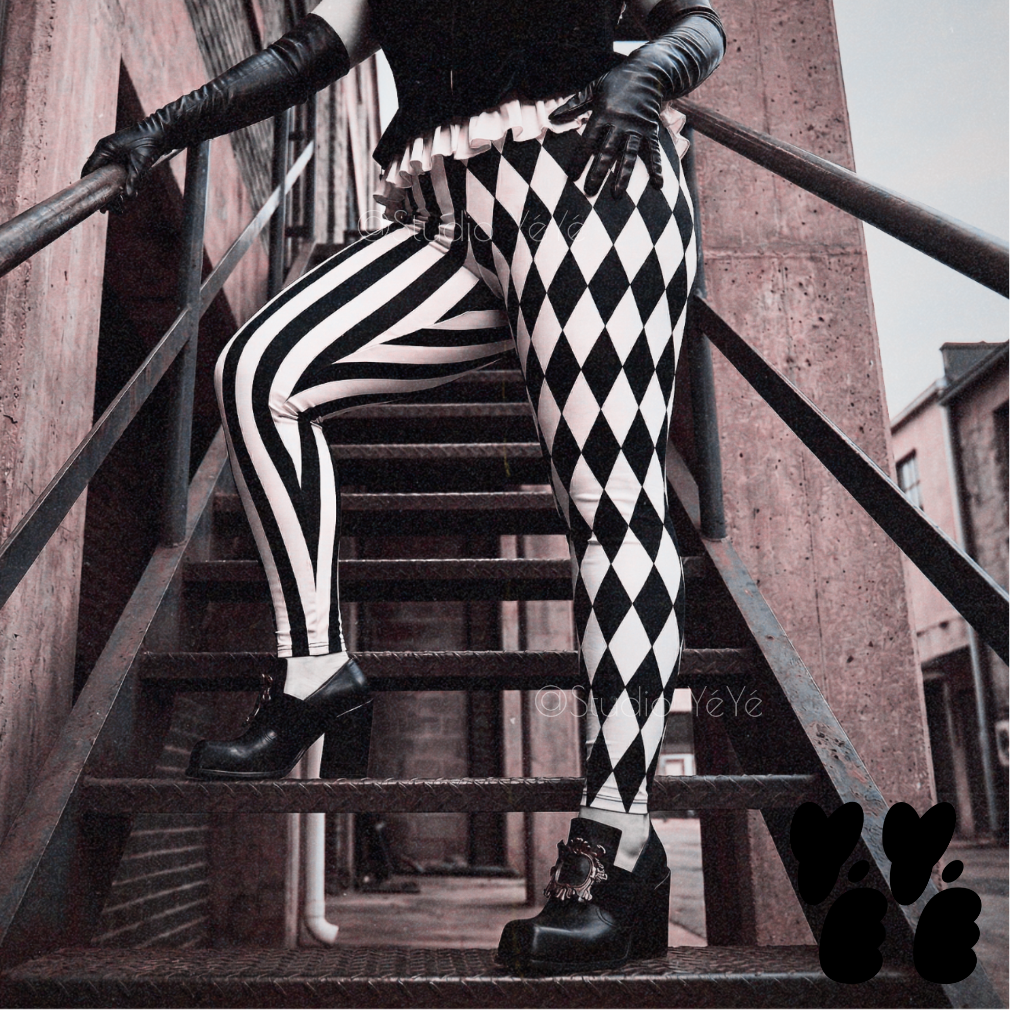 A female model wears velvet bustier, black leather gloves and black and white jester leggings from studio yeye with goth punk style platform shoes