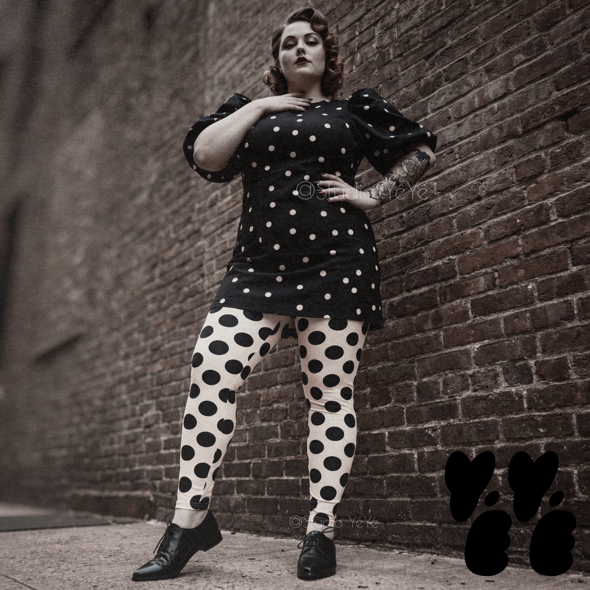 A plus size female model wears 2XL large polka dot leggings in black and white