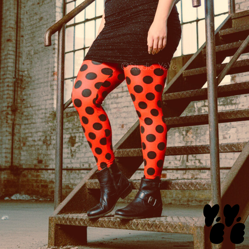 A plus sized female model wears 2XL large polka dot leggings in red and black, wears glitter mini dress and vintage boots