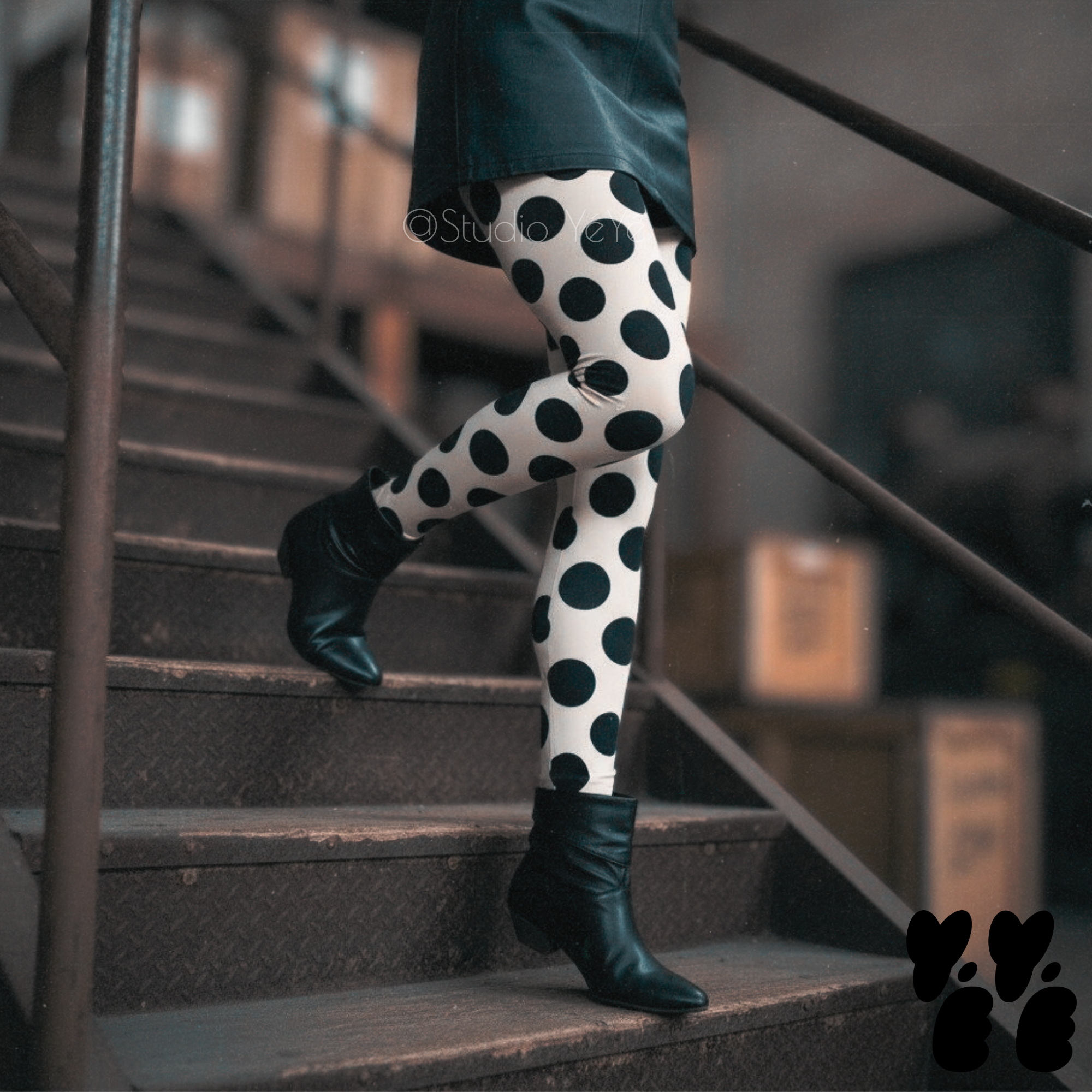 A model wears leather mini skirt with large polka dot leggings with 80s vintage boots