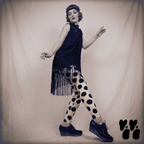 A flapper fashion girl wears 1930s vintage dress with large polka dot leggings with black platform shoes, posing like flapper dancer.