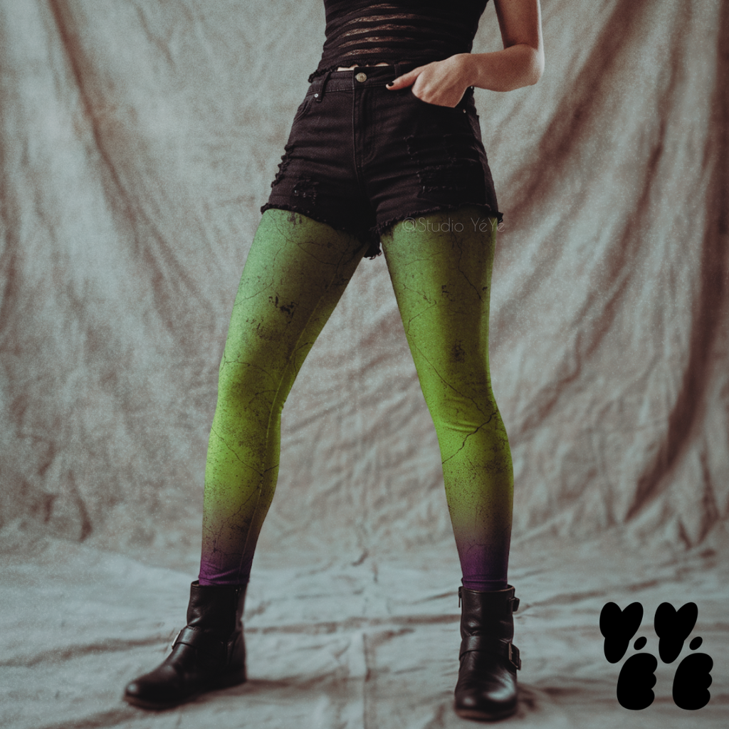 Model wearing toxic green leggings with a cracked, weathered wall texture fading to purple at the ankles, styled with black shorts and boots.