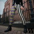 Model wearing purple and acid green harlequin diamond leggings paired with black and white striped legs and black boots.