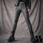 Model wearing black leggings with a subtle distressed spiderweb pattern, styled with a black leather jacket and platform boots.