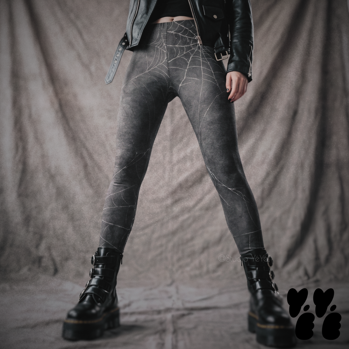 Model wearing black leggings with a subtle distressed spiderweb pattern, styled with a black leather jacket and platform boots.