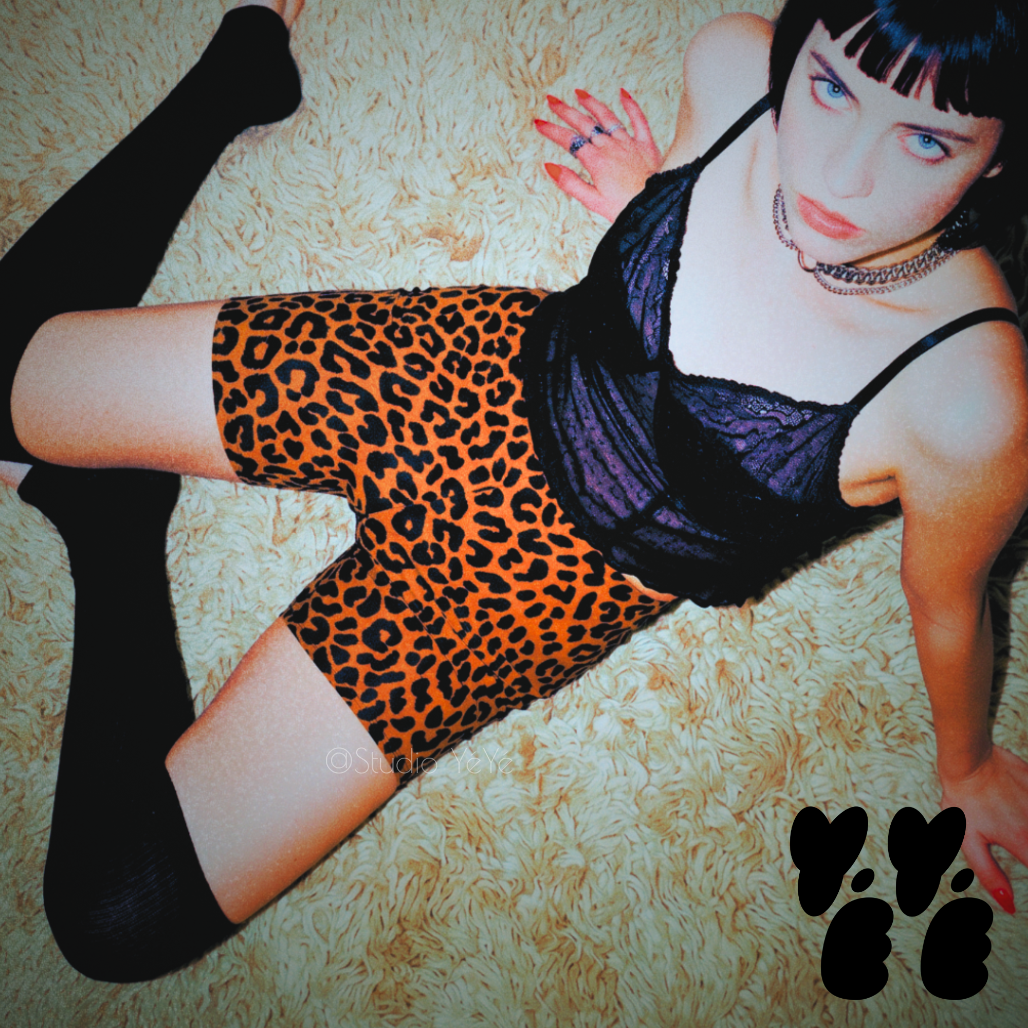 A punk style model wears caramel brown leopard bike shorts with see through camisole and knee-high socks on shaggy rag with attitude  