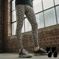 A genderless man wears leopard printed mens leggings in bone white with converse shoes