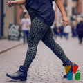A plus sized female model wears 2XL leopard leggings in moss green with vintage boot, walking in NYC