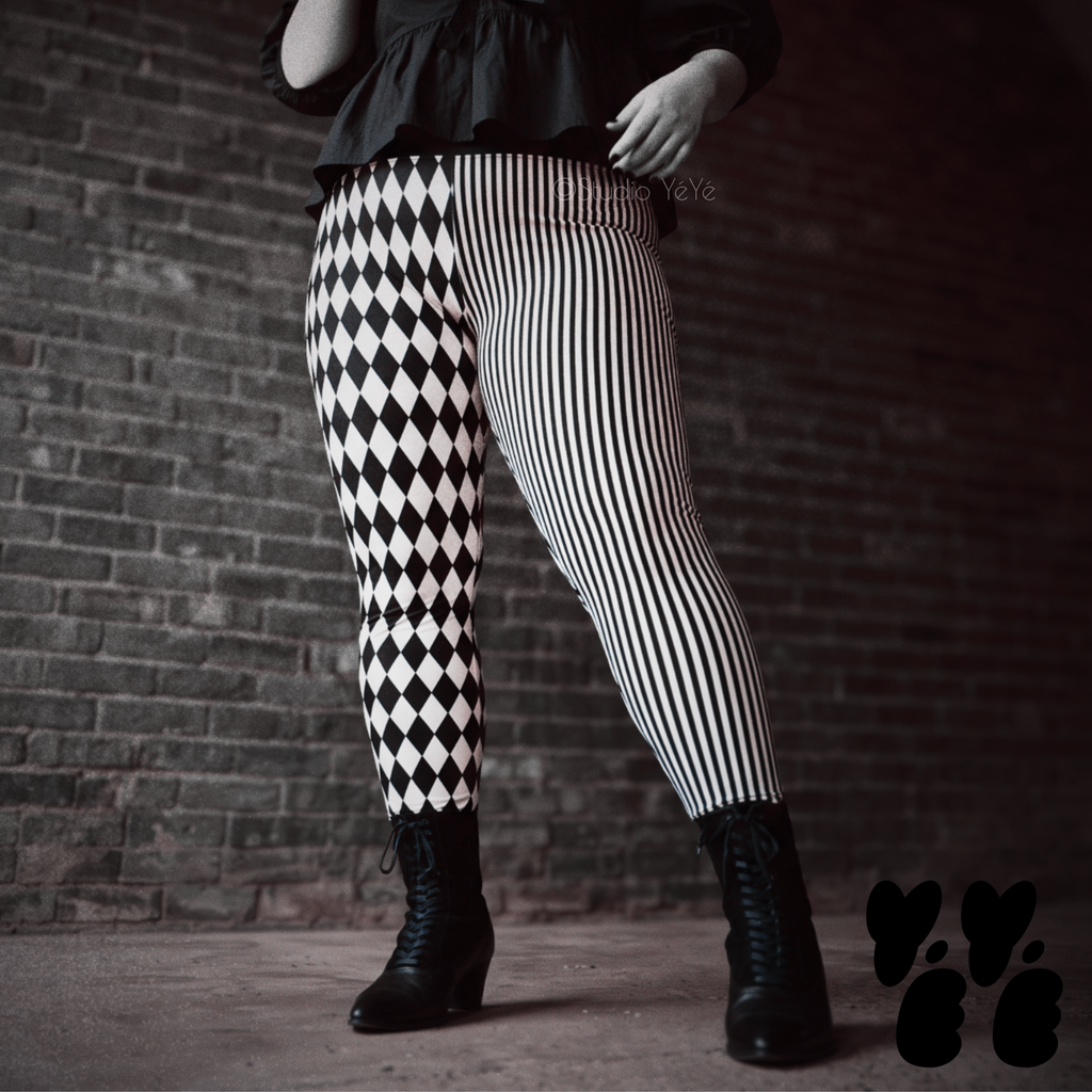 Model wearing black and white harlequin diamond and fine pinstripe leggings with a black lace top and black boots.