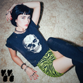 Neon yellow and black tiger stripe bike shorts by YéYé, styled with a vintage skull graphic tee, silver chain choker and black thigh-high socks on a shag carpet