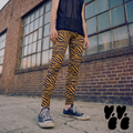 A genderless man wears tiger printed leggings for men in dark mustard yellow with converse shoes