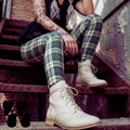 Green and cream tartan plaid leggings by YéYé, styled with a black mini skirt and cream lace-up brogue boots on rusty metal stairs