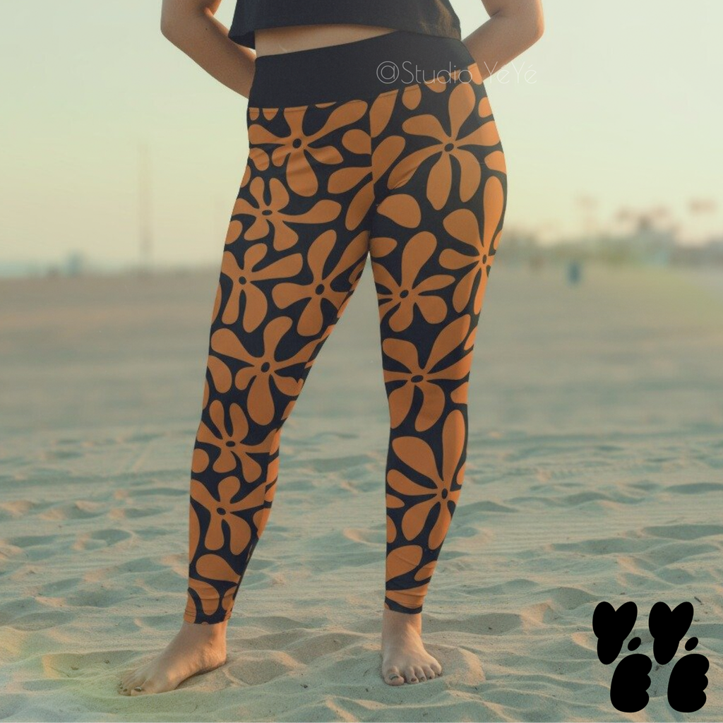 A plus size female model wears hawaiian print leggings in black and brown at venice beach in LA