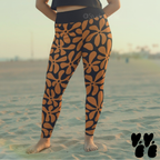 A plus size female model wears hawaiian print leggings in black and brown at venice beach in LA