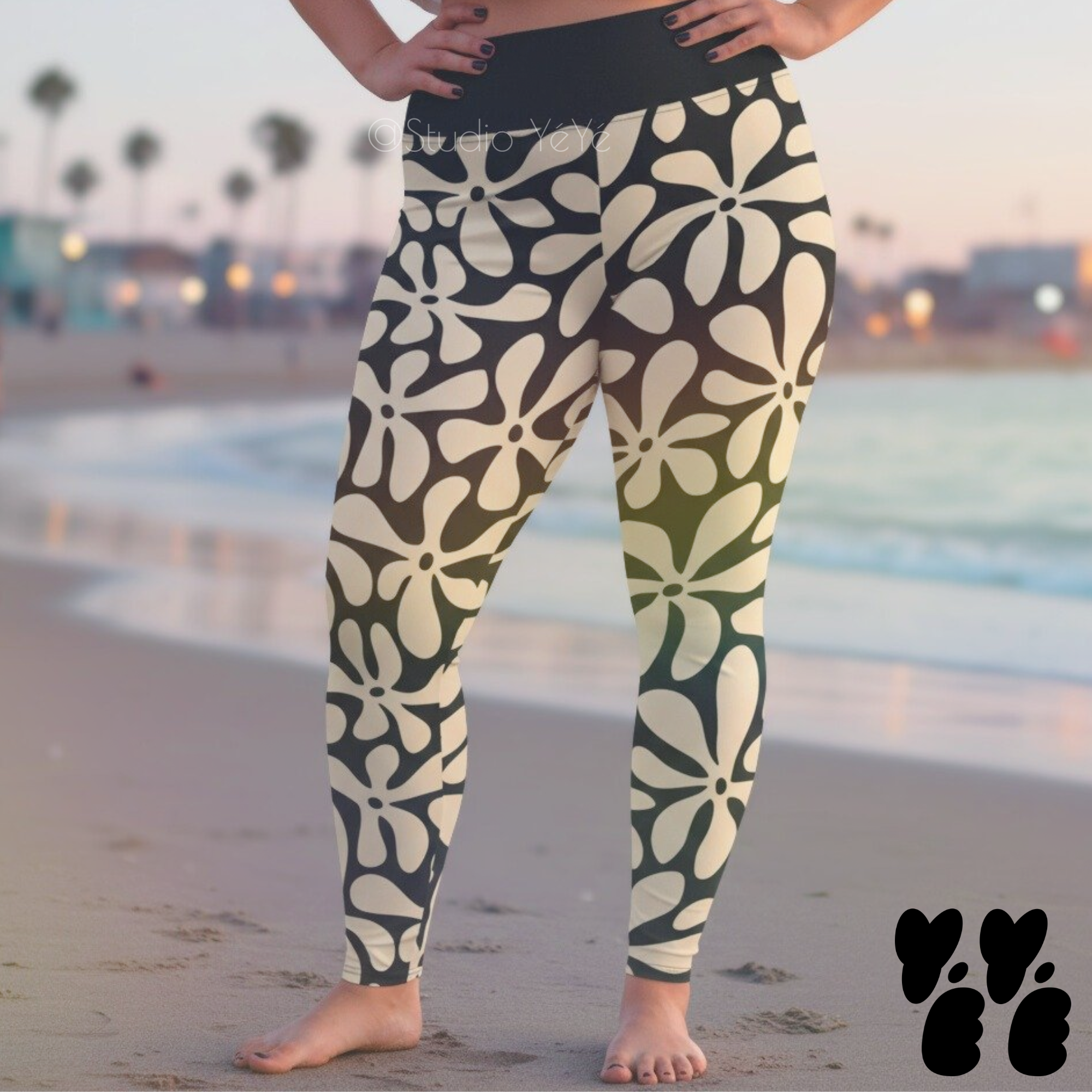 A plus size female model wears 2XL vintage hawaiian print leggings in off white and black at venice beach in LA