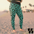 A plus sized female model wears 2XL vintage hawaiian print leggings in teal and black