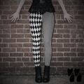 Model wearing black and white harlequin diamond and fine pinstripe leggings with a black lace top and black boots.